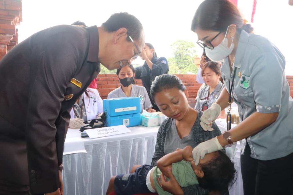 KICK OF: Wabup Ketut Suiasa meneteskan vaksin polio kepada balita dan anak-anak saat kick off Pekan Imunisasi Nasional (PIN) Polio tahun 2024 di Br. Gulingan, Desa Adat Tegal Darmasaba, Abiansemal.