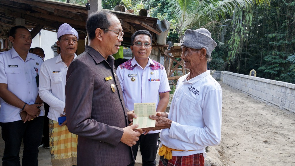 MENYERAHKAN BANTUAN: Wabup Ketut Suiasa saat menyerahkan bantuan fisik bangunan pasca bencana di Kecamatan Petang dan Kecamatan Abiansemal, Rabu 24 Juli 2024.