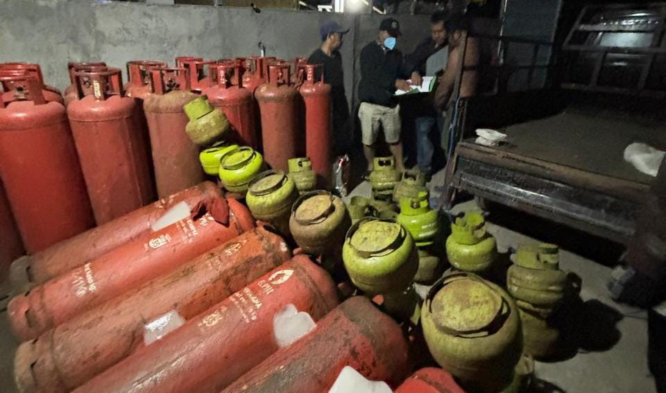SEDANG OPLOS: Polisi mendapati praktik ilegal oplos gas LPG dari tabung melon (3 kg) ke tabung besar di Peguyangan Gianyar