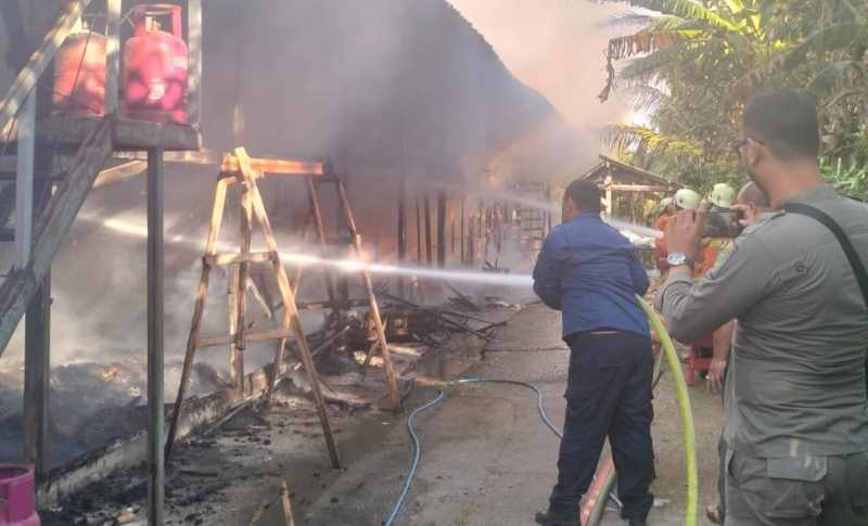 PADAMKAN API : Petugas pemadam kebakaran memadamkan api yang membakar kandang ayam. (polsek mendoyo/jembrana)