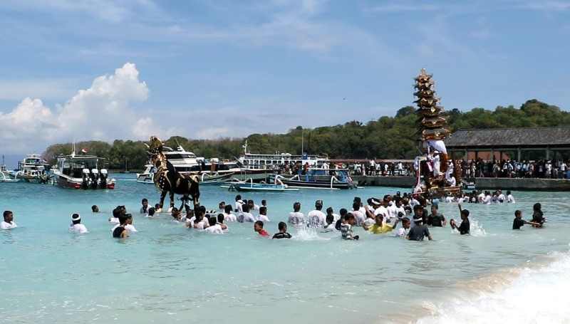 UNIK: Prosesi pengarakan bade dan lembu saat upacara pengabenan di Desa Padangbai, Kecamatan Manggis melewati laut sebelum memasuki setra. (Foto zulfika Rahman)