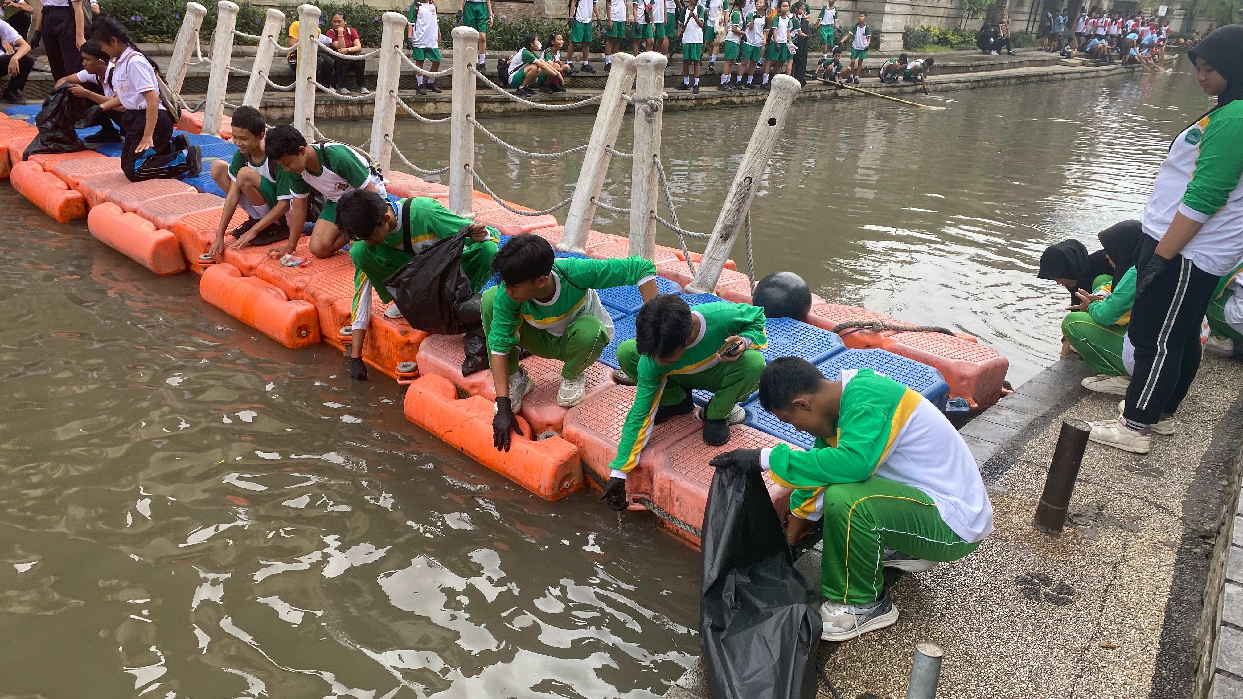 BERBAUR: Aktivitas memungut sampahj di air di area bantaran Tukad Badung di titik 1, Minggu 25 Agustus 2024.