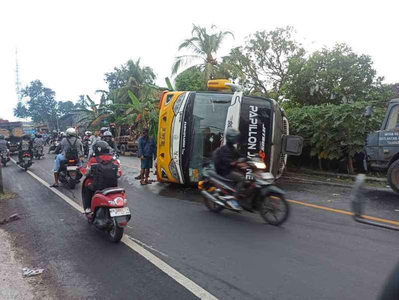 TERGULING : Kondisi bus pariwisata DK 7882 GB yang terguling di Jalan Raya Denpasar-Gilimanuk. (istimewa)