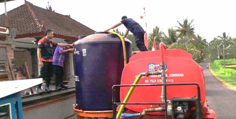 BAGIKAN AIR : Distribusi air bersih oleh BPBD Jembrana di Banjar Sari Kuning, Desa Tukadaya, Kecamatan Melaya, Selasa (3/9) lalu. (BPD Jembrana)