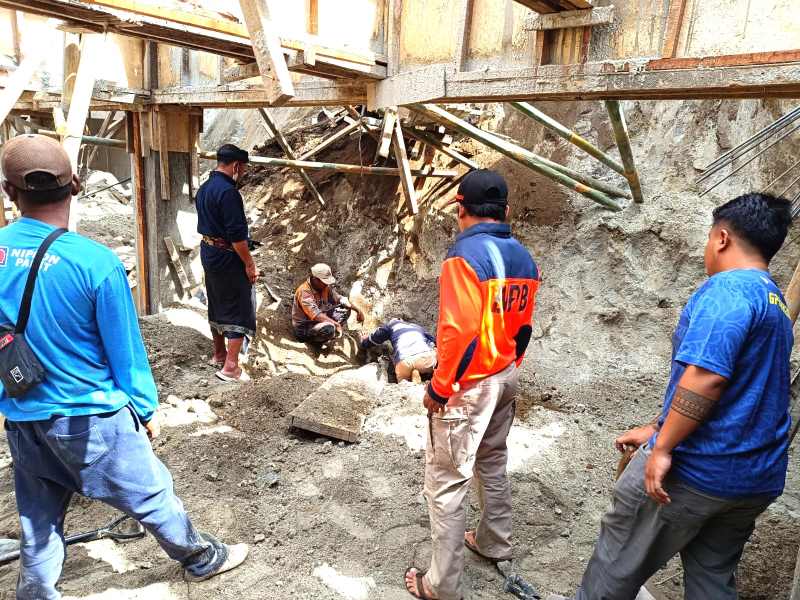 EVAKUASI KORBAN : Petugas mengevakuasi pekerja proyek tertimbun longsor saat bekerja di coffee shop Kintamani . (foto: BPBD Bangli)