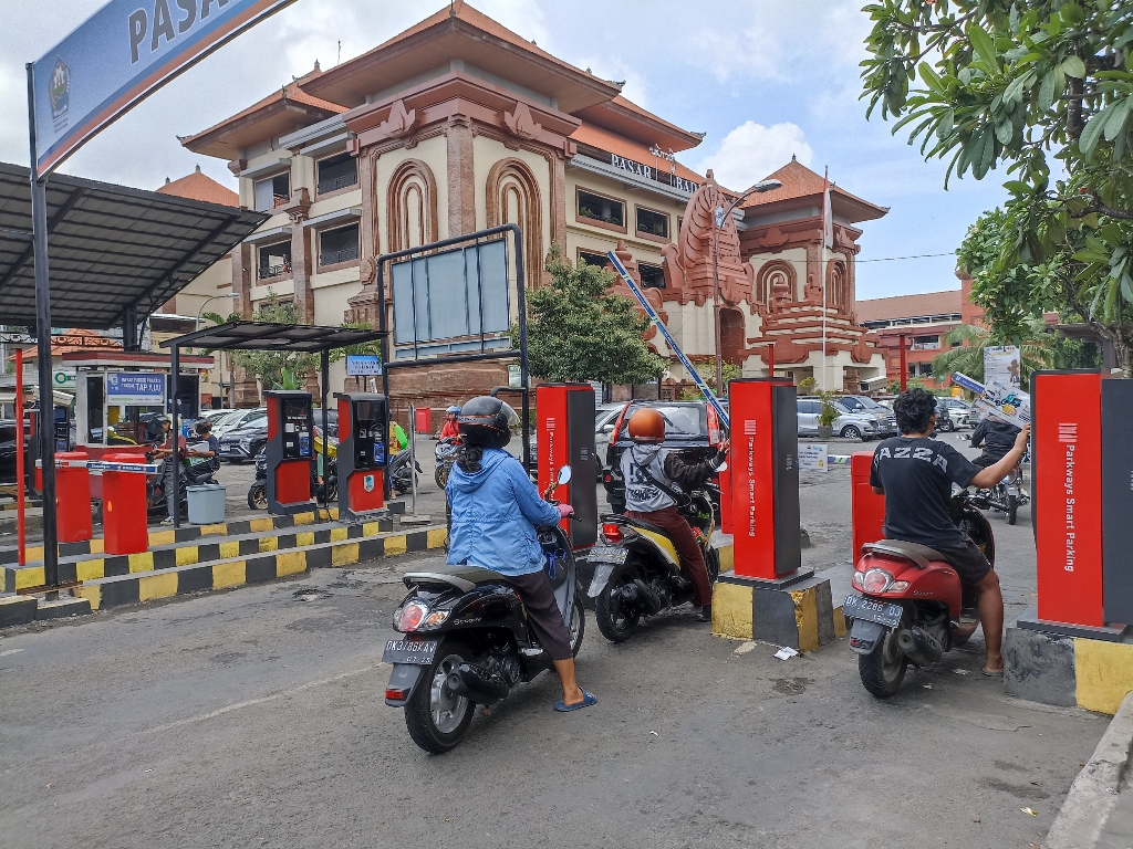 TARIF PARKIR: Pengambilan tiket parkir di pintu masuk Pasar Badung, Denpasar.