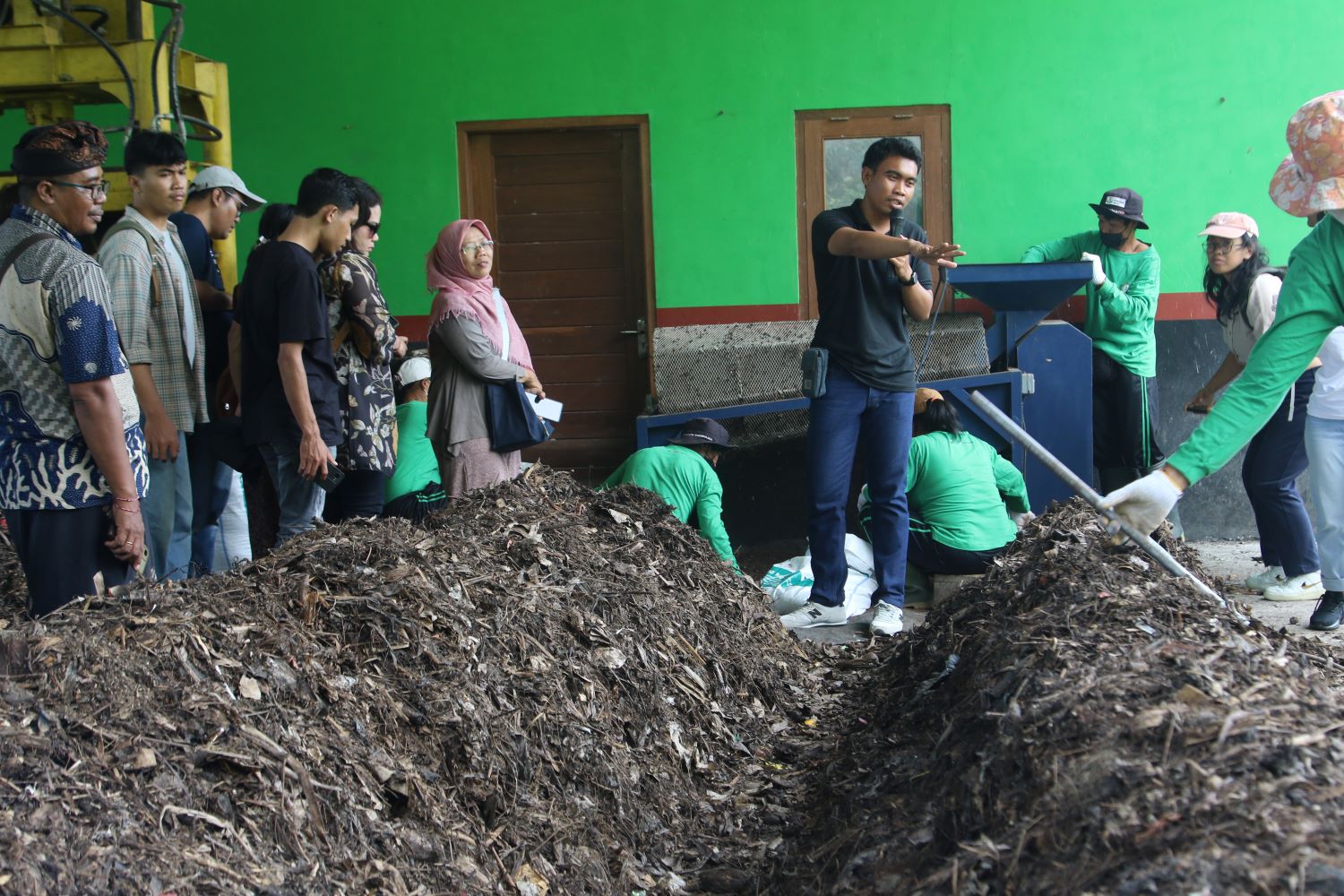 PENGOLAHAN SAMPAH: Manajer fasilitas TPS3R Desa Keliki, Gede Adnyana (kaus hitam pegang mik), menjelaskan proses pengolahan sampah pada para pengunjung, Minggu 8 September 2024