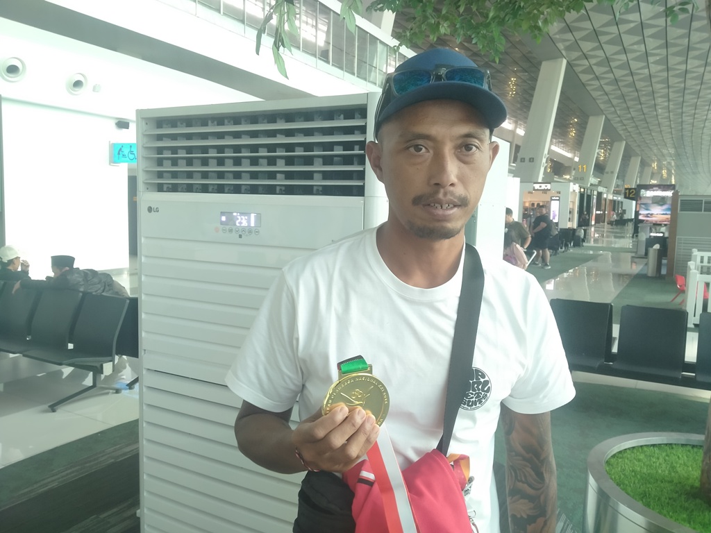 PEGANG MEDALI: I Wayan Wiranatha memegang medali emasnya saat ditemui di Bandara Soekarno-Hatta, Jakarta, Selasa, 17 September 2024.