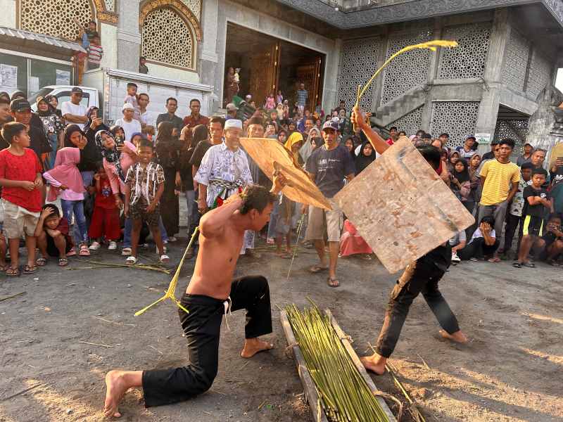 TRADISI YANG LESTARI : Atraksi seni gebuk ende di Banjar Kecicang Islam, Karangasem saling pukul dengan menggunakan batangan pohon ilak.[ Foto Zulfika Rahman]