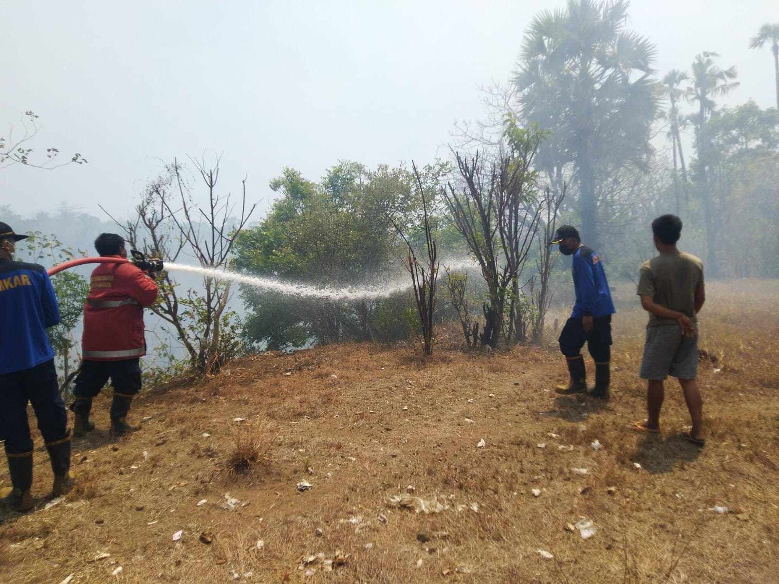 PADAMKAN API  : Petugas Damkartan Karangasem saat melakukan pemadaman api yang menyala di TPST Desa Culik, Kecamatan Abang.(Istimewa)