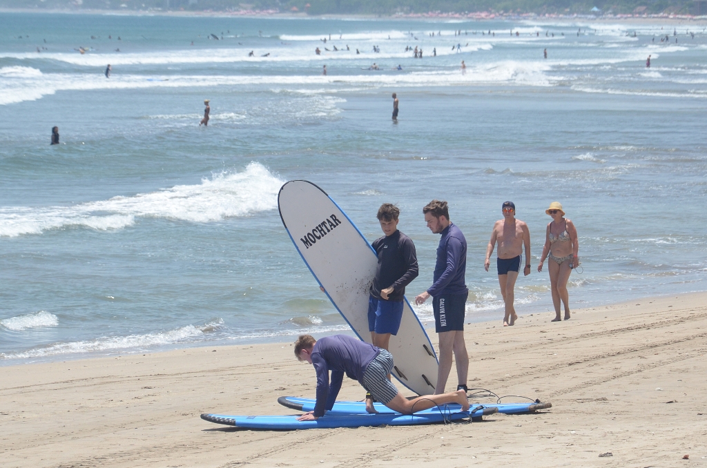 SURFING: Salah satu WNA diduga sebagai pelatih surfing di Pantai Kuta.