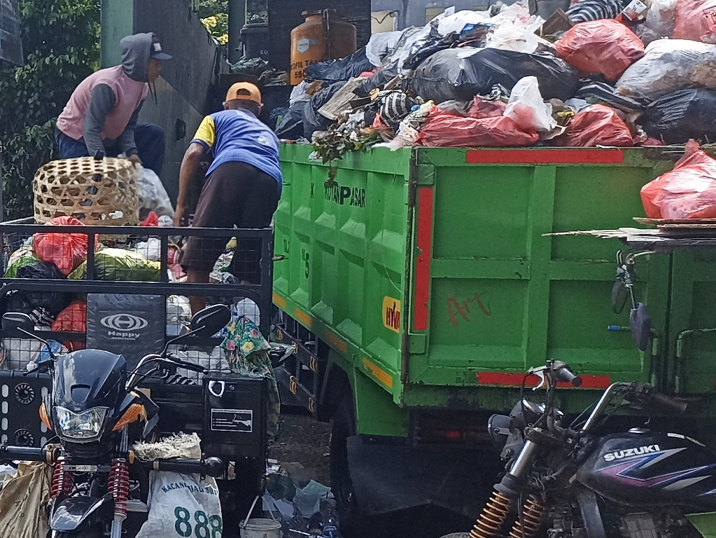 PEMILAHAN: Petugas DLHK Denpasar saat menampung sampah yang sudah terpilah di salah satu TPS  di Denpasar.