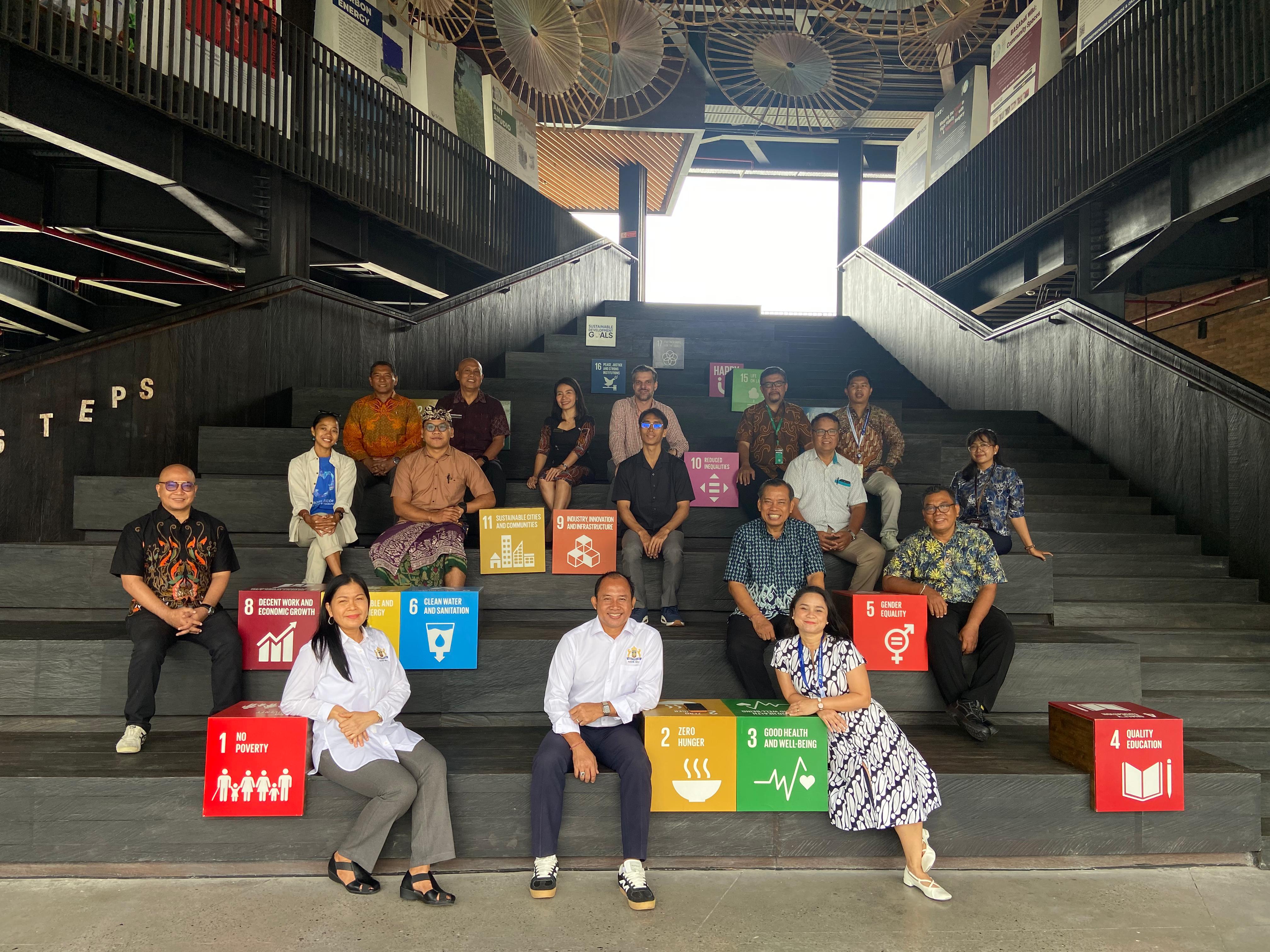 Peserta FGD berfoto di tangga bertema Sustainable Development Goals (SDGs) di UID Bali Campus.