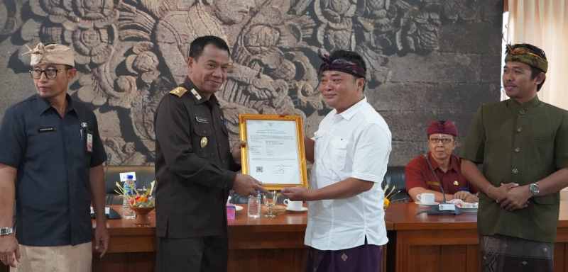 DAPAT PLAKAT: Pj Bupati Buleleng, Ketut Lihadnyana menyerahkan sertifikat HKI ke salah satu penerima. Mereka diharapkan terus melakukan inovasi. (Foto: Pemkab Buleleng untuk Radar Bali)
