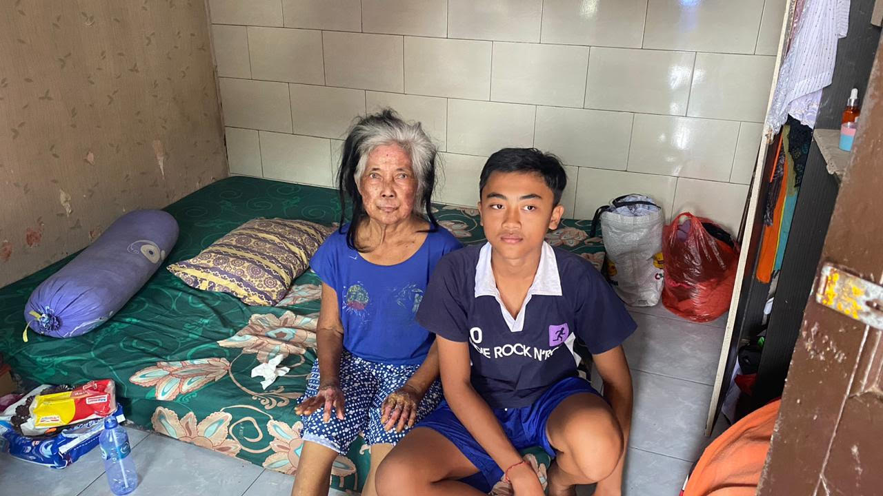BERSAMA NENEK : Gede Krisna Angga Wiguna bersama sang nenek yang kini dalam kondisi sakit akibat luka bakar 40 persen. (Foto zulfika Rahman/Radar Bali)