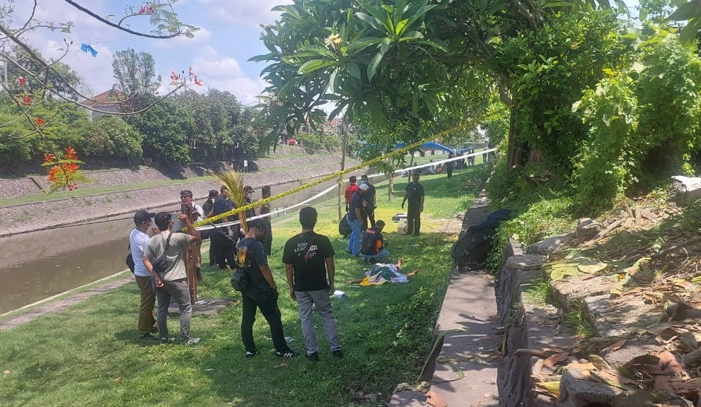 POLICE LINE: Warga dan aparat memasang garis polisi di area penemuan mayat Mr X di bantaran Sungai Taman Pancing Timur Denpasar, 7 November 2024.