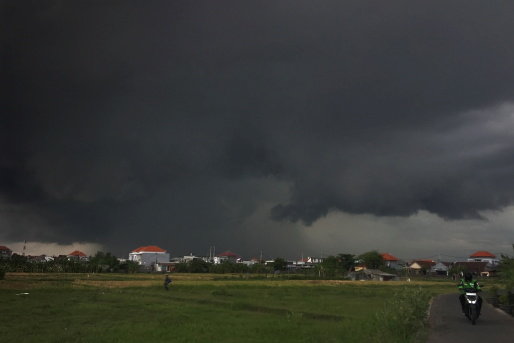 MENDUNG: Langit mendung kawasan persawahan Pedungan, Denpasar Selatan, kemarin (19/11).