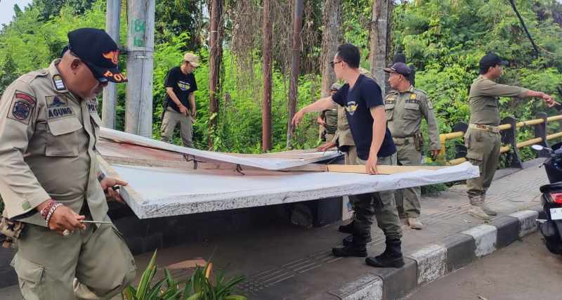 MEMANG SAATNYA DITURUNKAN: Petugas gabungan dari unsur KPU, Bawaslu hingga Satpol PP berangus baliho di masa tenang. (Foto: KPUD Gianyar)