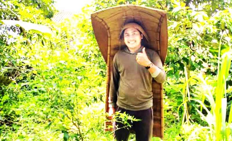 KHAS : Made Danu Tirta pemuda desa asal Wangaya, Penebel memakai payung cukup khas petani di Tabanan zaman dulu. (Foto Made Danu Tirta untuk Radar Bali)