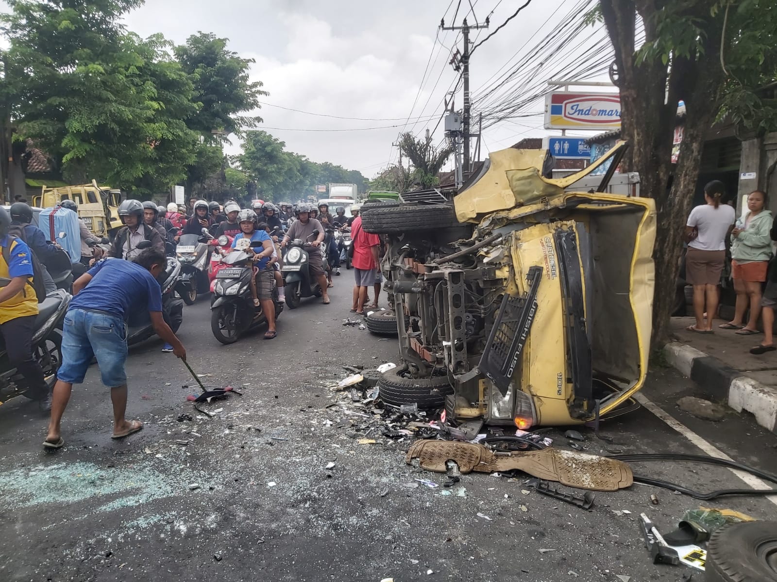 MACET PANJANG: Mobil yang terbalik akibat kecelakaan diangkat oleh warga dan polisi, di Jalan Raya Denpasar-Gilimanuk, depan Pura Desa Puseh, Banjar Tengah, Desa Lukluk, Mengwi, Badung