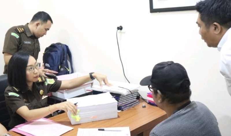TUNTASKAN PEMBERKASAN : Tersangka korupsi LPD I Komang Suarjana alias Mang Brend (pakai topi)saat tahap dua kepada jaksa penuntut umum Kejari Jembrana. (foto:Kejari Jembrana)