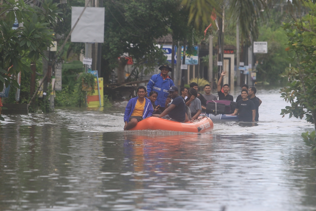 EVAKUASI: Tim dari Balawisata Badung saat evakuasi wisatawan dengan rubber boat dari vila kawasan Jalan Dewi Sri IV yang terdampak banjir, Minggu 22 Desember 2024.
