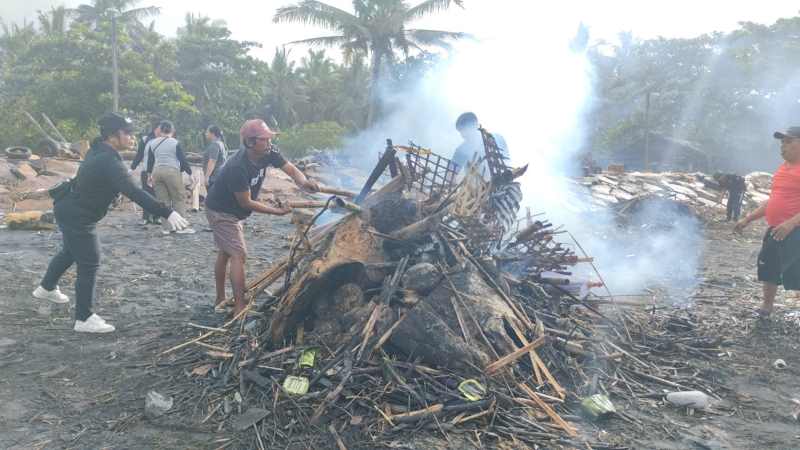 DIKUMPULKAN DAN DIBAKAR Sampah kiriman berupa bambu, ranting dan batang kayu menumpuk di Pantai Soka, Selemadeg Tabanan,ini dibakar. (juliadi/radar bali)