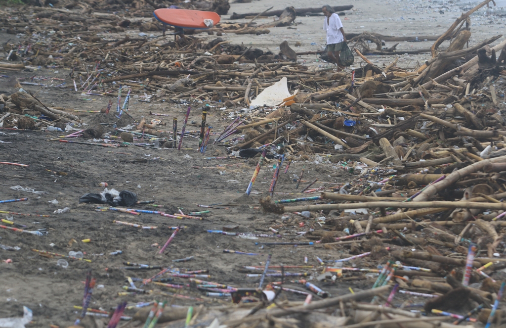 PENUH SAMPAH: Sejumlah sampah bekas kembang api yang dinyalakan saat perayaan malam tahun baru yang telah bercampur dengan sampah kayu mengotori kawasan Pantai Kuta dan sekitarnya, Rabu 1 Januari 2025