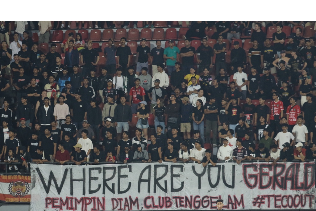 KRITIS: Spanduk yang dibentangkan suporter mempertanyakan Manager Bali United Michael Gerald. Suporter juga tetap memnuntut Teco out dari Bali United.
