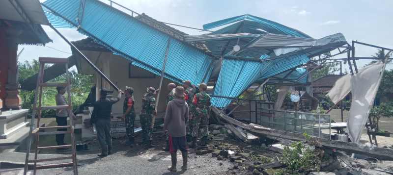 GOTONG ROYONG: Penanganan usai kemunculan angin puting beliung dilakukan warga dibantu anggota TNI dan Polri di Banjar Dinas Bugbugan Sari, Desa Senganan Penebel Tabanan. (juliadi/radar bali)