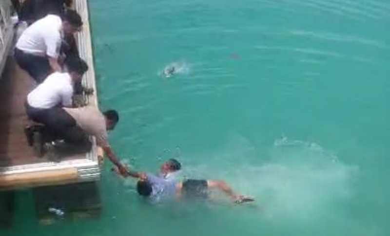 SIBUK MENARIK ODGJ: Petugas Tengah berusaha keras menarik ODGJ ke atas. (istimewa)