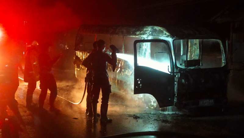 DRAMATIS : Petugas kerja keras memadamkan api yang membakar mobil travel minibus, Minggu (26/1/2025) malam. (Foto: Damkar Jembrana)