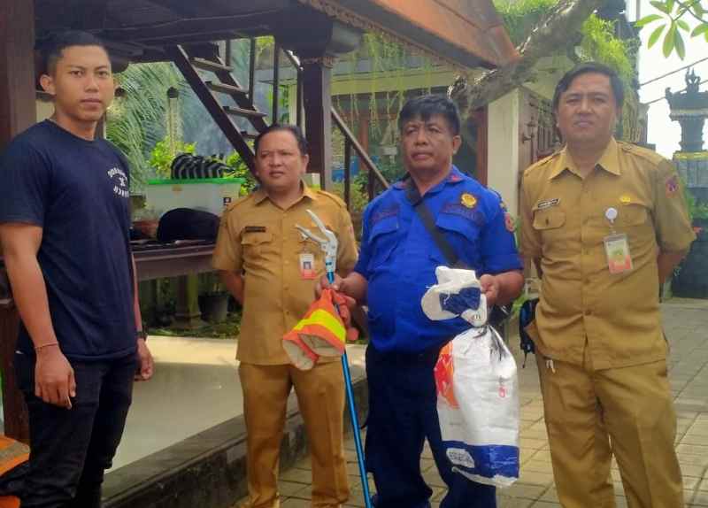 TANGKAP ULAR : Petugas Damkartan Karangasem saat melakukan evakuasi ular yang masuk ke rumah warga. (Foto damkartan Karangasem)