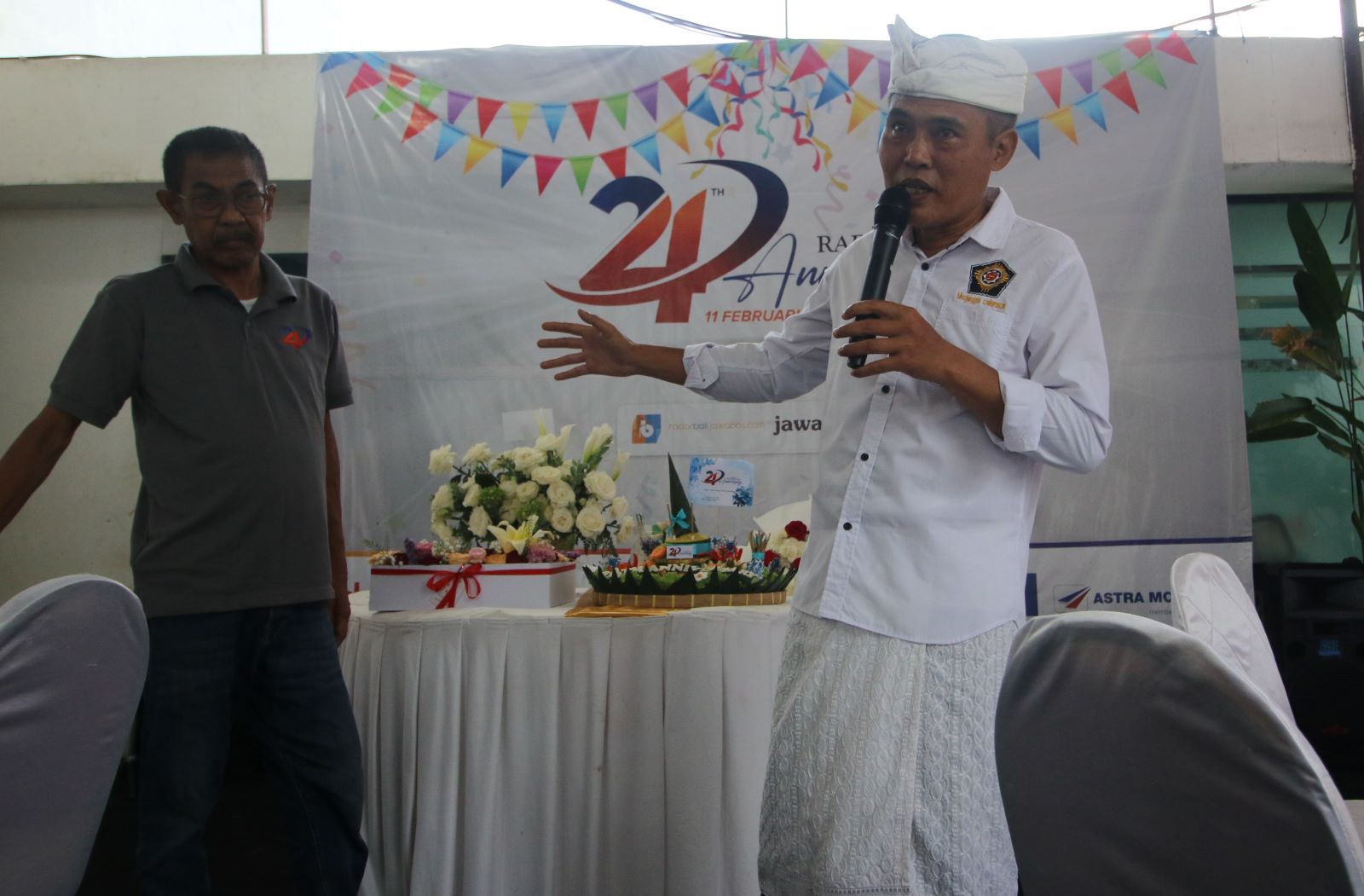 TETAP EKSIS: Anggota DPRD Bali Made Rai Warsa (baju adat putih) saat memberikan prakata di HUT Jawa Pos Radar Bali ke-24, pada 11 Februari 2025.