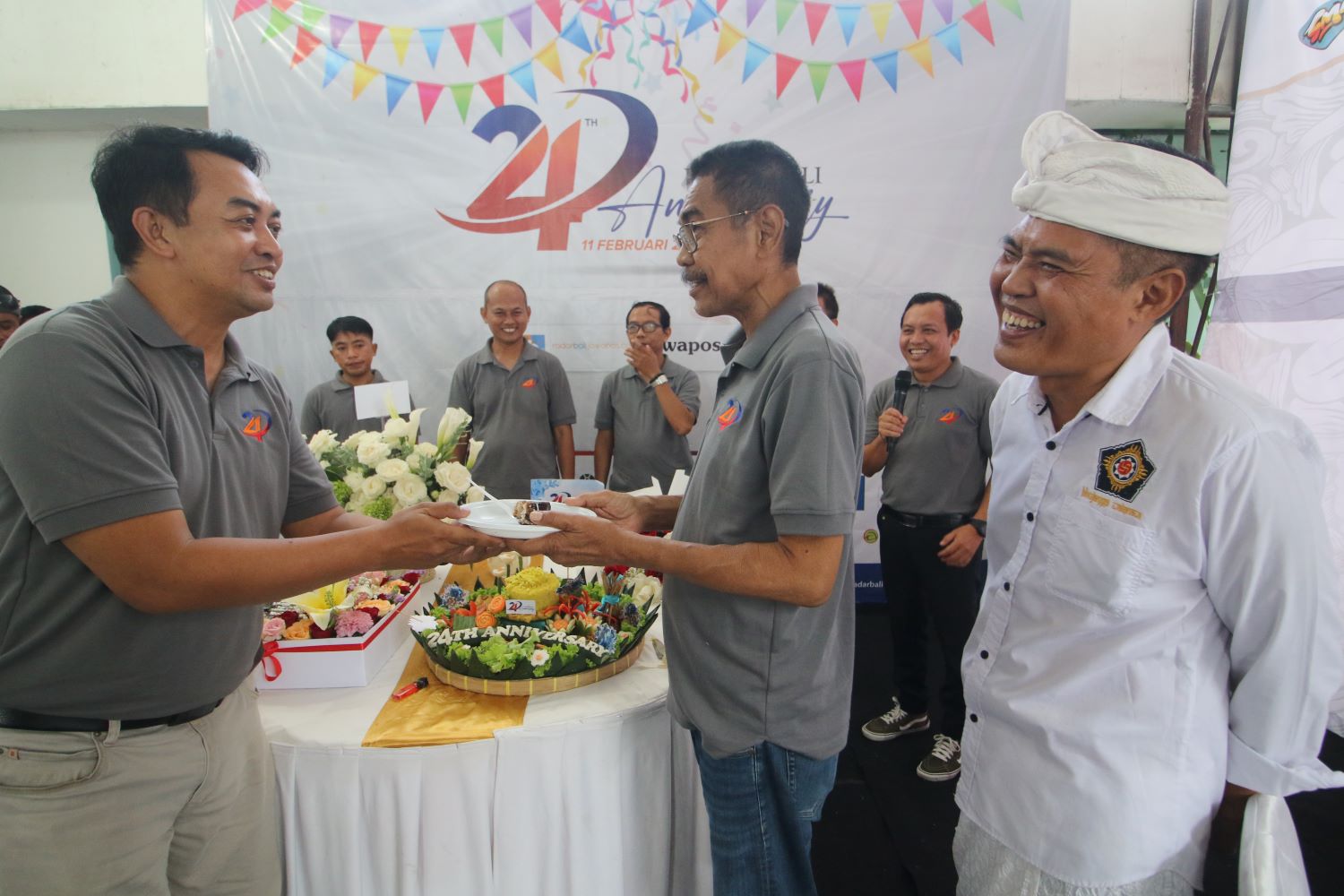 MOMENTUM: Wakil Direktur Jawa Pos Radar Bali Ibnu Yunianto memberikan kue tar kepada Direktur Justin M Herman disaksikan Made Rai Warsa yang kini anggota DPRD Bali