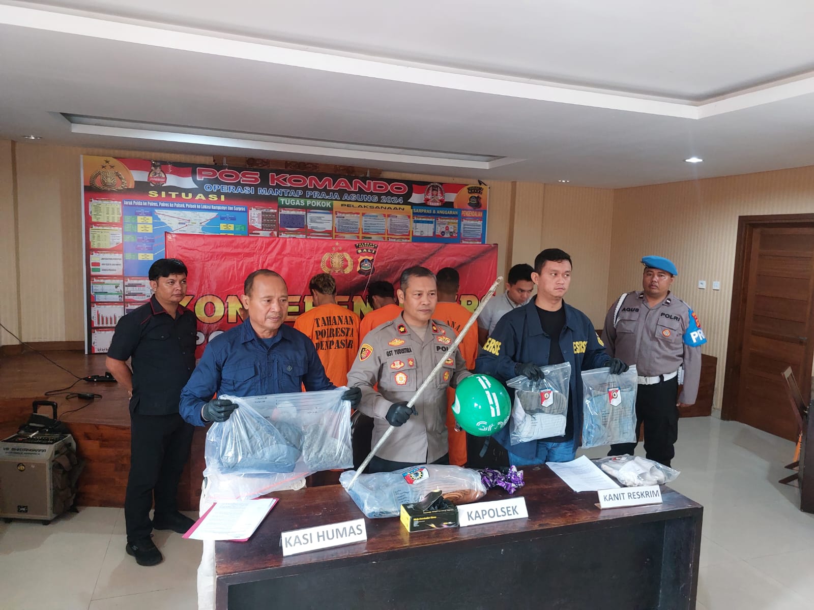 DIAMANKAN: Empat tersangka pengeroyokan dikenakan pakaian tahanan dan polisi tunjukkan barang bukti yang dipakai bikin onar.