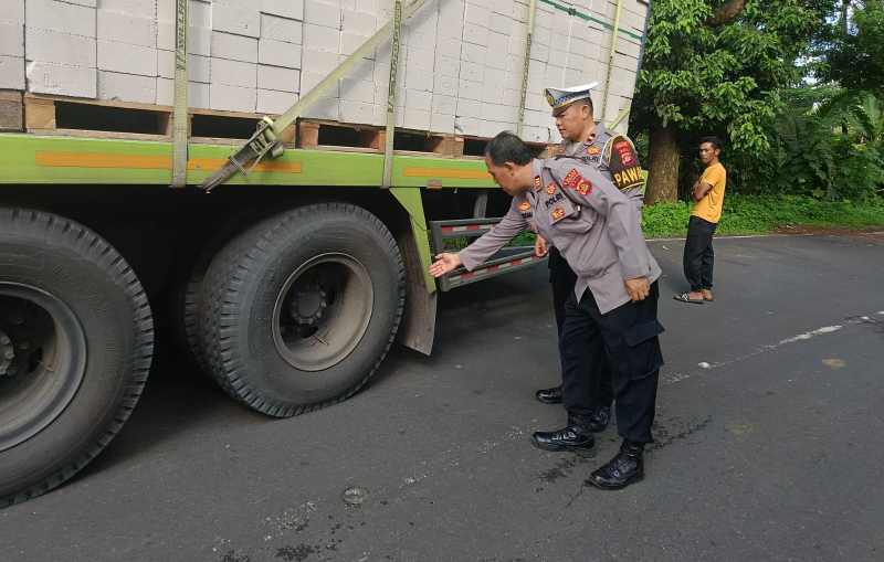 CEK TEMPAT KEJADIAN: Polisi mengecek truk tronton yang menggiilas motor di Jalan Denpasar-Gilimanuk Banjar Dinas Megati Kelod, Desa Megati Selemadeg Timur, Tabanan.(juliadi/radar bali)
