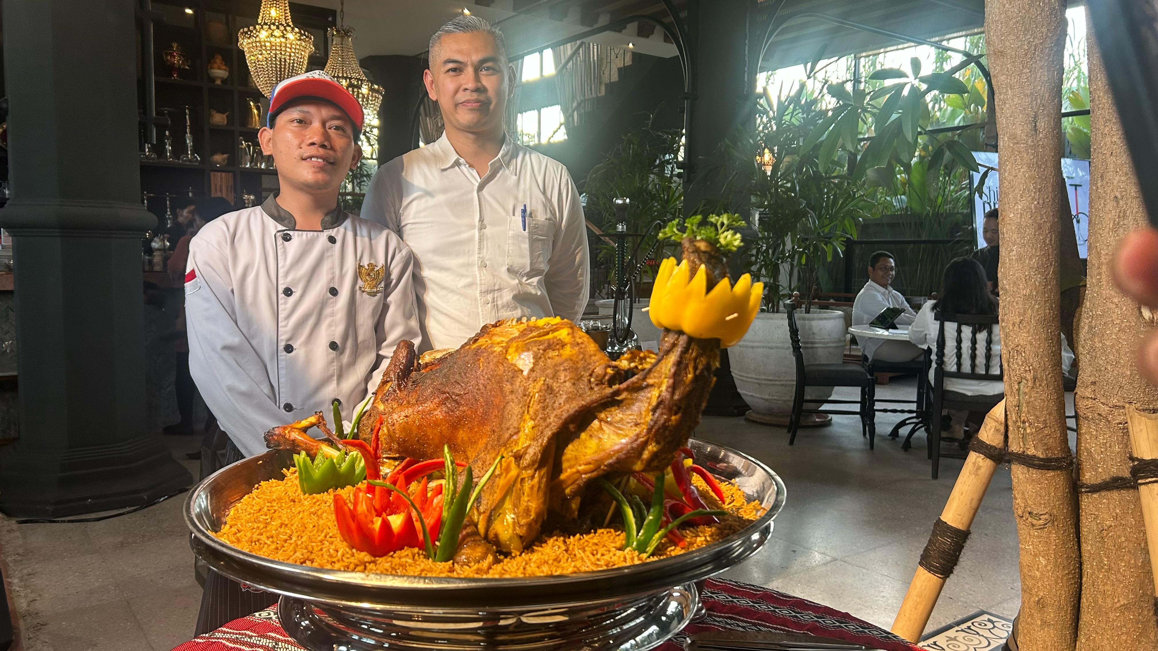 AUTHENTIC BUMBU TIMUR TENGAH: Chief Manager Al Jazeerah Signature Bali Rei Patriani (kanan) memperlihatkan menu Kambing Duduk, Senin (3/3/2025). (Rosihan Anwar/Radar Bali)