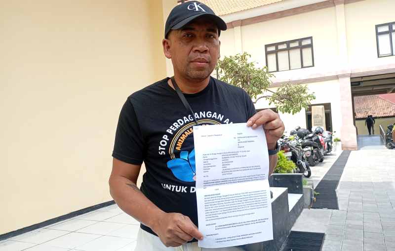 MELAPOR: Founder Yayasan Animals Hope Shelter Indonesia, Christian Joshua Pale, menunjukkan pengaduannya ke Polres Buleleng terkait  penembakan anjing di Desa Sidetapa.(francelino junior)