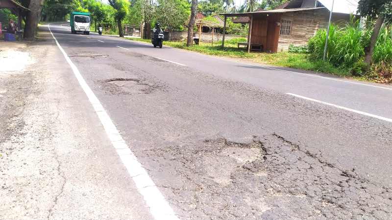 DIKEBUT TAMBALANNYA : Kondisi jalan  nasional Denpasar-Gilimanuk yang rusak di wilayah Jembrana ini masih menunggu waktu perbaikan. (foto:m.basir/radar bali)