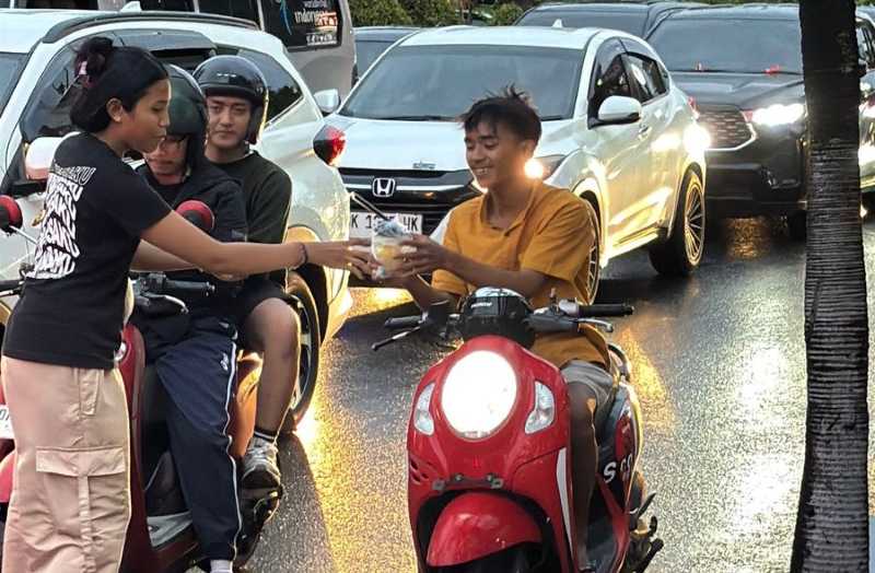 SISIHKAN UANG SAKU UNTUK BERBAGI : Anak- anak pegiat teater SMAN 1 Kuta Tengah membagikan takjil di di  Jalan Dewi Kunti, Seminyak, Kuta, Badung. (foto : Istimewa)