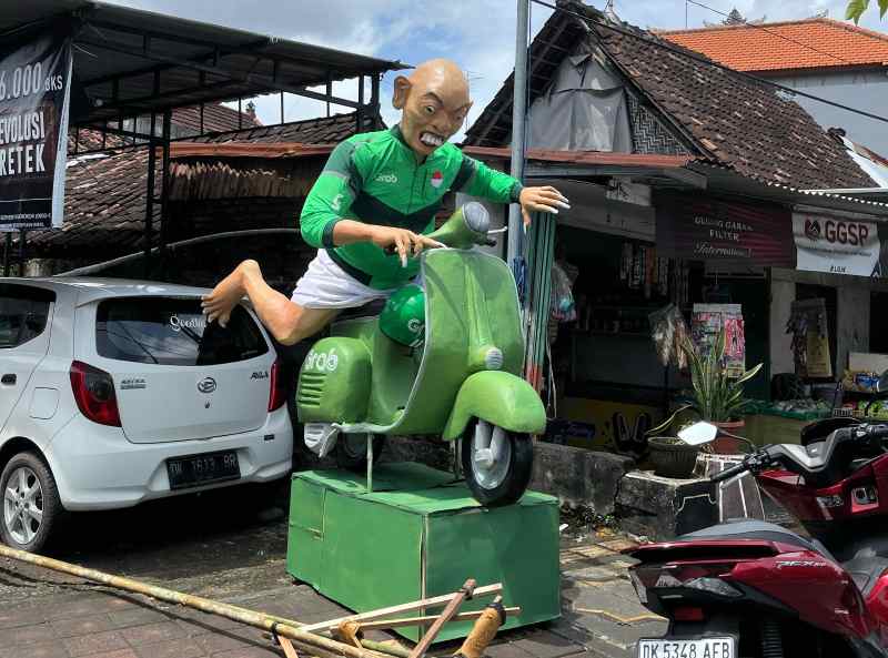 UNIK ANTIMAINSTREAM : Ogoh-ogoh pengojek online naik skuter di Jalan Sutomo, Denpasar. (Fajar Bagaskara untuk Radar Bali)