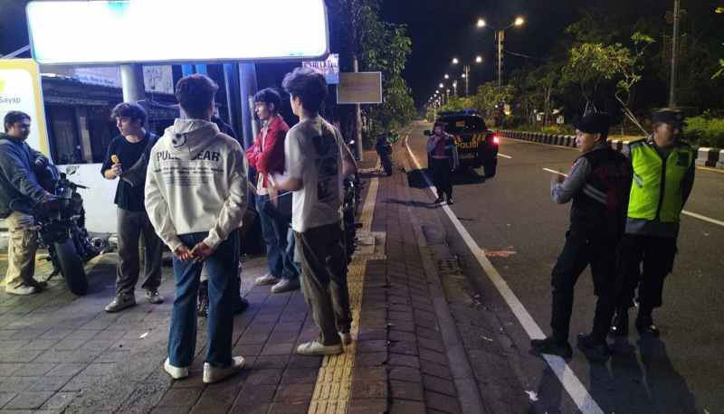 TURIS KURANG AJAR : Pihak Kepolisian bubarkan kelompok warga negara asing yang hendak balap liar dan menggerombl di depan Indomaret, depan LPD Bualu.(foto:istimewa)
