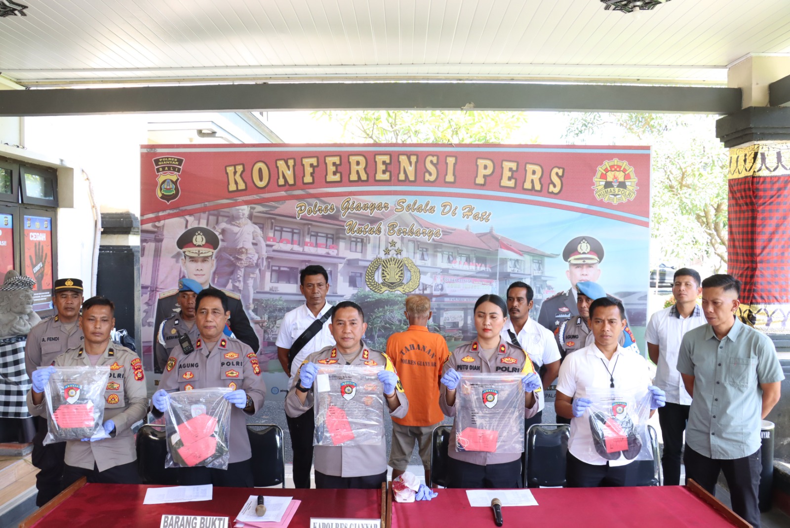 TUNJUKKAN BUKTI: Kapolres dan Wakapolres Gianyar menunjukkan pisau dan pakaian yang digunakan pelaku menganiaya korban.