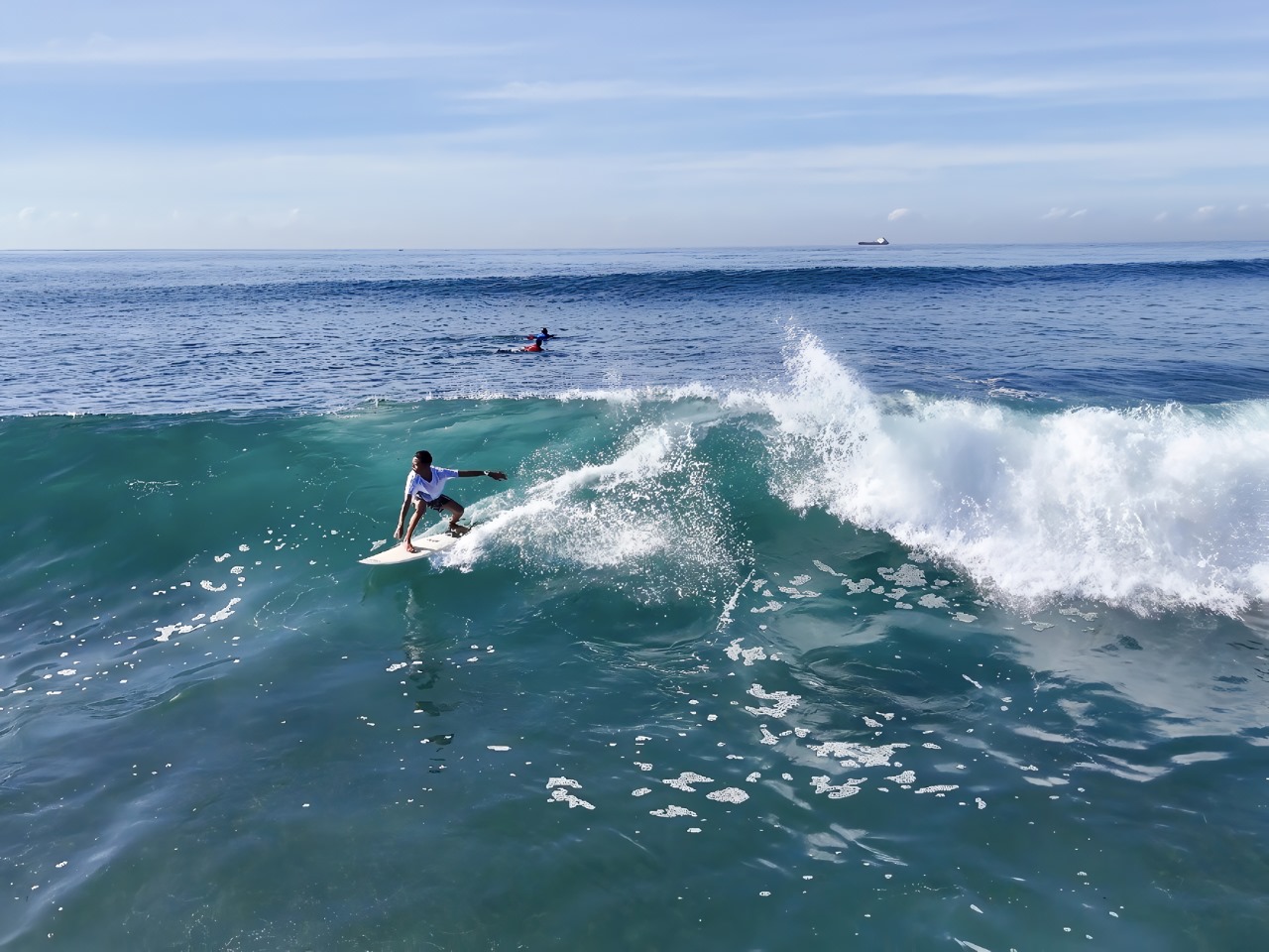 Peselancar Bali Dharma Wisesa membelah ombak di lepas pantai Serangan dan menjadi juara U-12 dalam laga final Grom Challenge pada Sabtu, 5 April 2025.