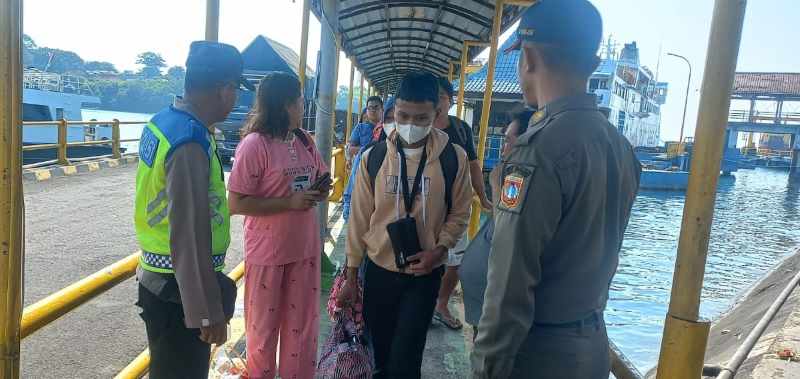 PERIKSA PENUMPANG : Petugas saat melakukan pemeriksaan terhadap penumpang yang baru tiba di Pelabuhan Padangbai, Karangasem. (zulfika Rahman/Radar Bali)