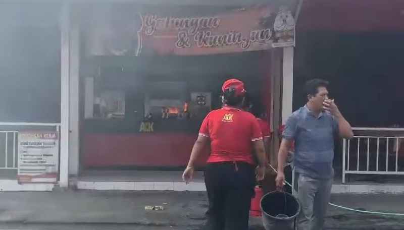 API MASIH KECIL: Karyawan dan warga tidak berdaya menghadapi api yang terus membesar di rumah makan cepat saji ACK Batubulan. (foto:istimewa)