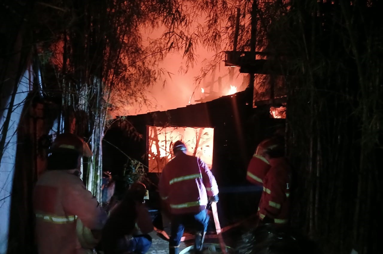 MENYALAK: Petugas menyiram kobaran api yang membakar salah satu villa di Jalan Gunung Guntur, Padangsambian, Denpasar Barat, saat Galungan