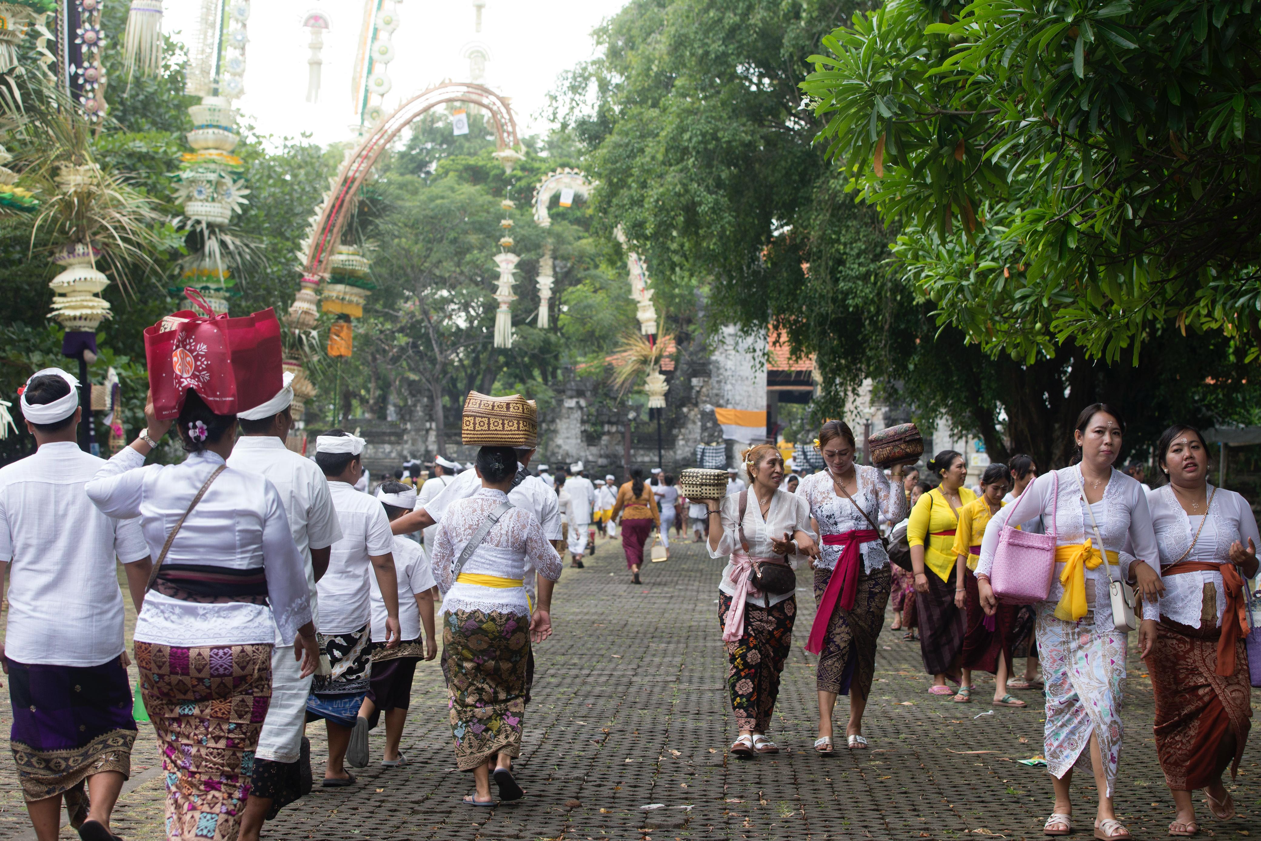 WARNA TRI HITAKARANA: Ribuan pemedek dengan pakaian adat silih berganti melakukan persembahyangan di Pura Sakenan tepat saat Wuku Kuningan 2 Mei 2025.
