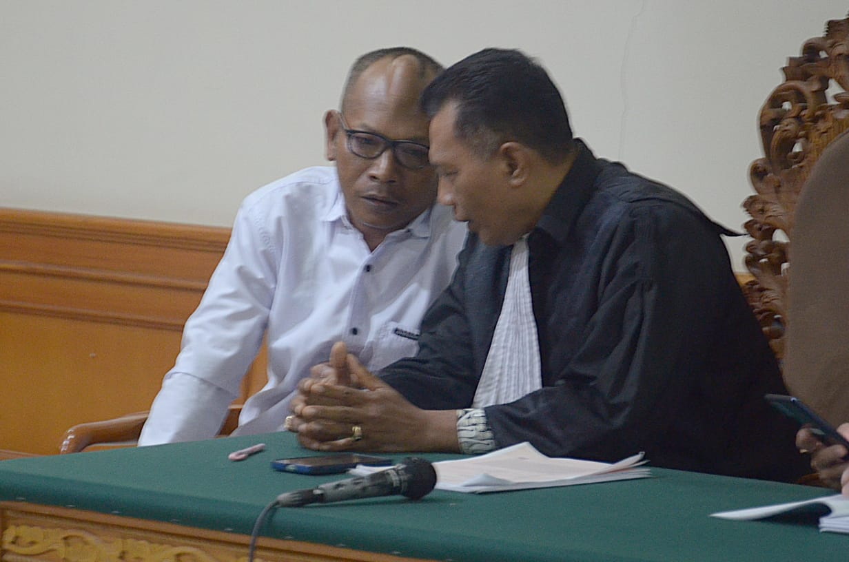MINTA NASIHAT: Terdakwa I Komang Suarjana (kiri) koordinasi dengan pengacaranya usai mendengar tuntutan di Pengadilan Tipikor Denpasar, Rabu (7/5/2025).